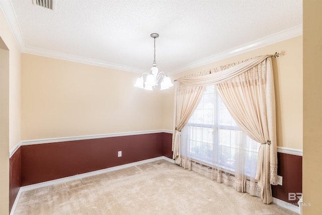 empty room with a notable chandelier, a textured ceiling, carpet floors, and crown molding