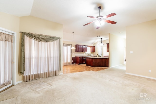 living room with a healthy amount of sunlight, lofted ceiling, ceiling fan, and light colored carpet