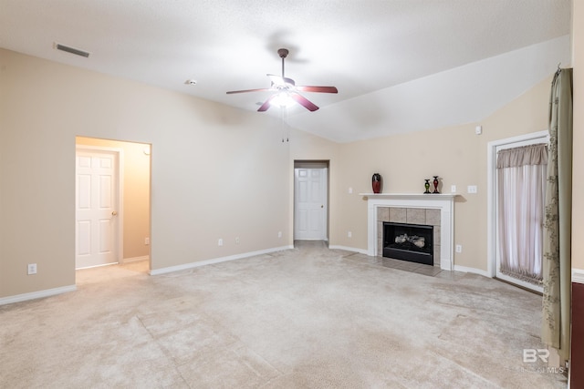 unfurnished living room with light carpet, lofted ceiling, a tiled fireplace, and ceiling fan