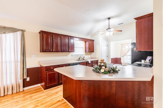 kitchen with ceiling fan, lofted ceiling, sink, kitchen peninsula, and light hardwood / wood-style floors