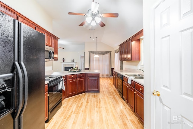 kitchen featuring vaulted ceiling, black appliances, ceiling fan, light hardwood / wood-style flooring, and sink