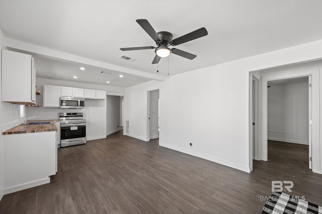 kitchen featuring ceiling fan, dark wood-type flooring, sink, stainless steel appliances, and white cabinetry