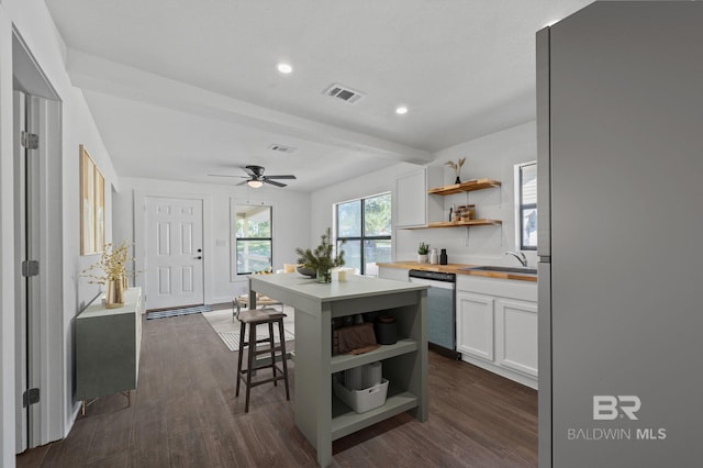 kitchen featuring dark wood-type flooring, a center island, stainless steel appliances, and white cabinets