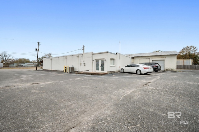 view of car parking with a garage and french doors