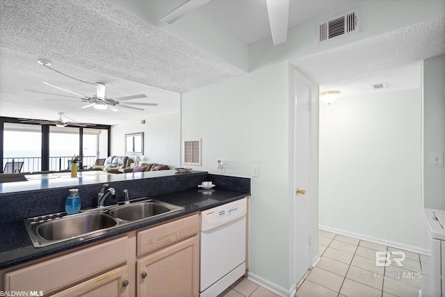 kitchen featuring visible vents, a sink, dark countertops, dishwasher, and ceiling fan