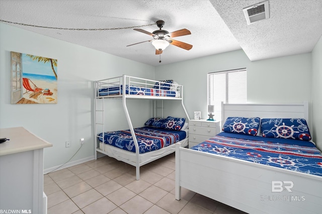 bedroom featuring visible vents, a textured ceiling, light tile patterned flooring, and a ceiling fan