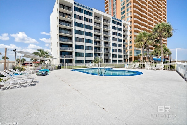 community pool featuring a patio area and fence