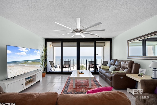 living room featuring a textured ceiling, tile patterned floors, and ceiling fan