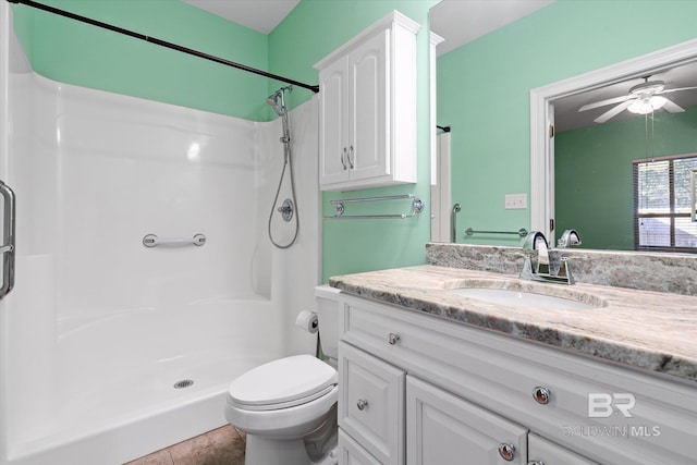 bathroom with ceiling fan, vanity, toilet, tile patterned floors, and a shower