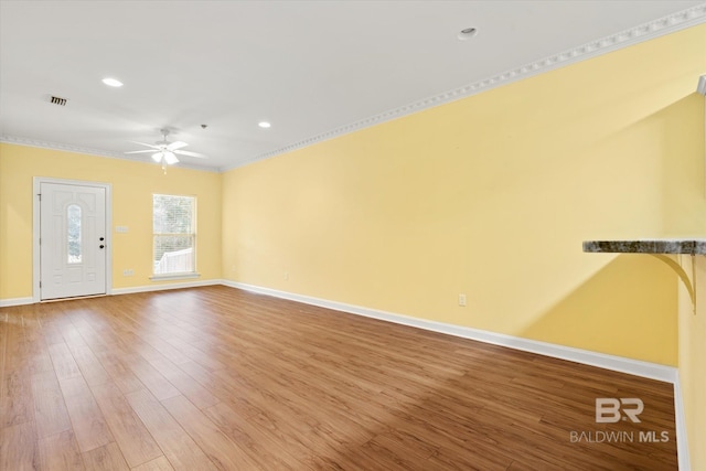 unfurnished living room featuring ceiling fan, hardwood / wood-style floors, and ornamental molding