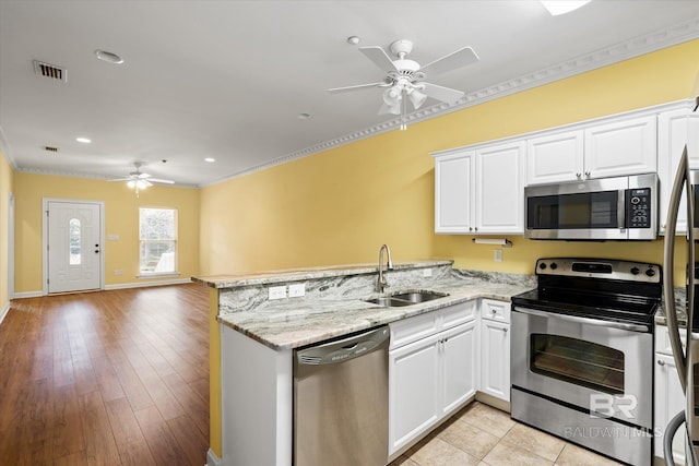 kitchen featuring white cabinets, stainless steel appliances, sink, kitchen peninsula, and crown molding