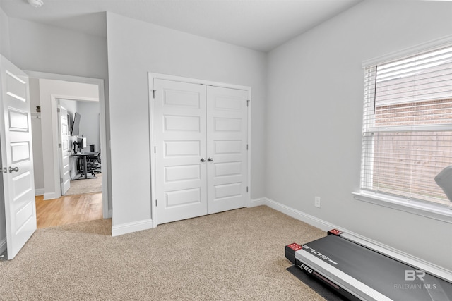 exercise room with a wealth of natural light and light carpet