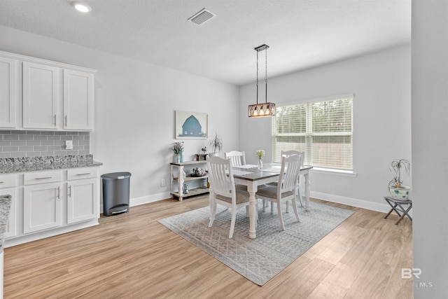 dining space with a chandelier and light hardwood / wood-style floors