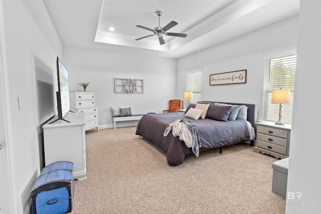 carpeted bedroom with ceiling fan and a raised ceiling