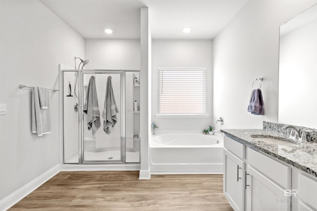 bathroom featuring independent shower and bath, vanity, and wood-type flooring