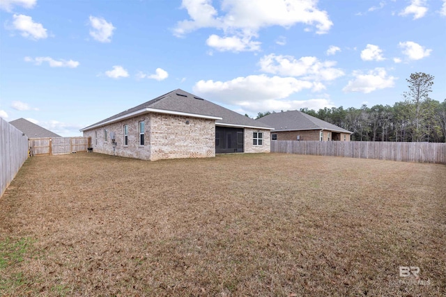 back of property with a sunroom and a lawn