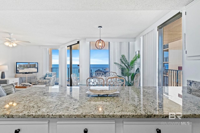 24400 Perdido Beach Blvd Unit 501, Orange Beach, AL 36561 - kitchen featuring a textured ceiling, ceiling fan, and light stone countertops