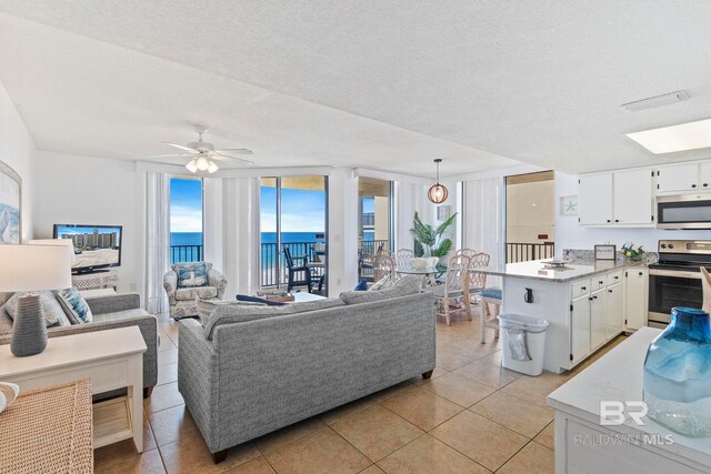 24400 Perdido Beach Blvd Unit 501, Orange Beach, AL 36561 - living room featuring light tile patterned floors, a textured ceiling, and ceiling fan