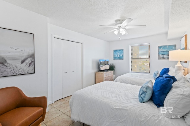 24400 Perdido Beach Blvd Unit 501, Orange Beach, AL 36561 - bedroom featuring light tile patterned floors, a closet, ceiling fan, and a textured ceiling