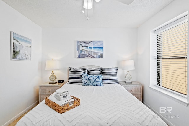 24400 Perdido Beach Blvd Unit 501, Orange Beach, AL 36561 - bedroom featuring baseboards, ceiling fan, and a textured ceiling