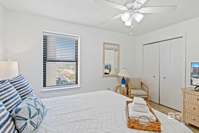 24400 Perdido Beach Blvd Unit 501, Orange Beach, AL 36561 - tiled bedroom with a closet, a textured ceiling, and a ceiling fan