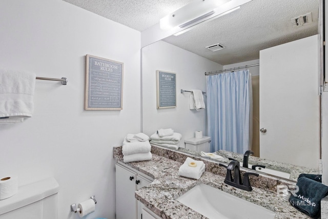 24400 Perdido Beach Blvd Unit 501, Orange Beach, AL 36561 - bathroom with visible vents, toilet, vanity, and a textured ceiling