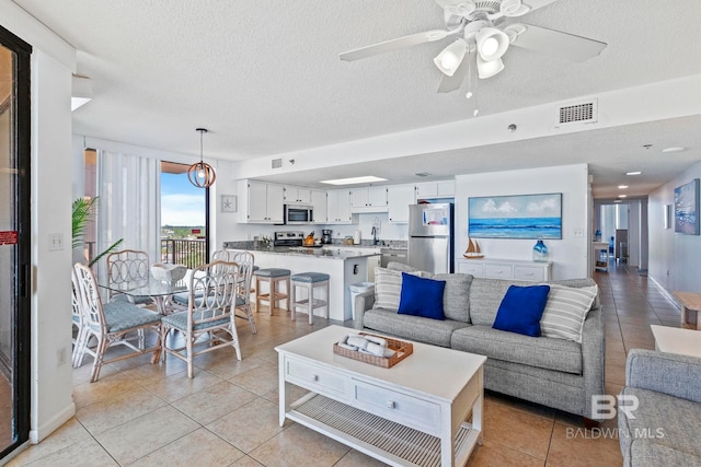 24400 Perdido Beach Blvd Unit 501, Orange Beach, AL 36561 - living room with a ceiling fan, light tile patterned floors, a textured ceiling, and visible vents