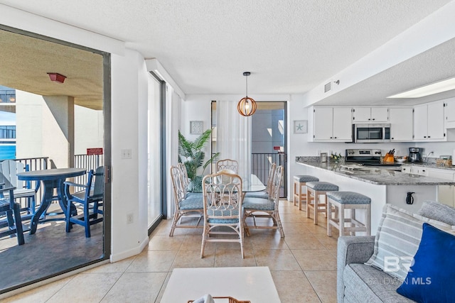 24400 Perdido Beach Blvd Unit 501, Orange Beach, AL 36561 - dining area with light tile patterned floors, baseboards, a textured ceiling, floor to ceiling windows, and visible vents