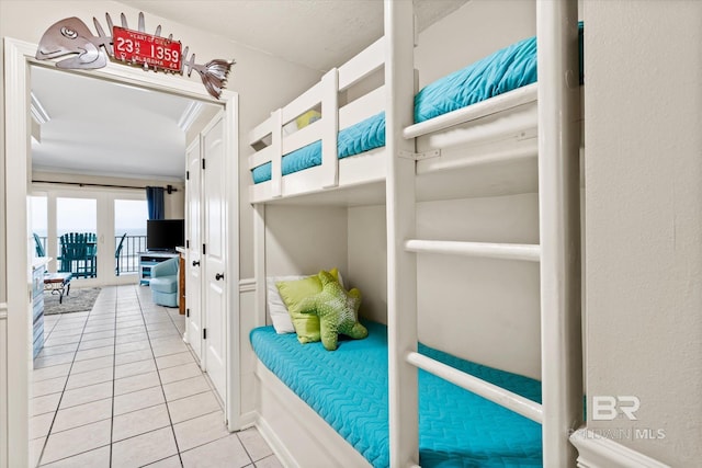 tiled bedroom featuring crown molding and french doors