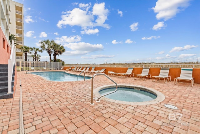 view of swimming pool with a hot tub