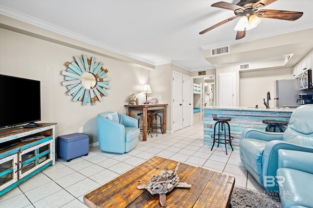 living room featuring ornamental molding, sink, light tile patterned floors, and ceiling fan