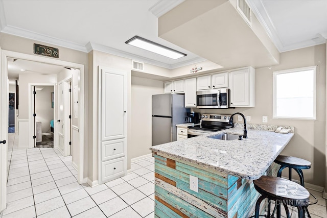 kitchen with sink, white cabinetry, crown molding, a kitchen breakfast bar, and stainless steel appliances