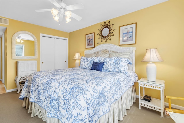 carpeted bedroom with ceiling fan and a closet