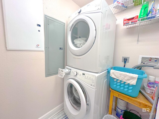 washroom with stacked washer / dryer and electric panel