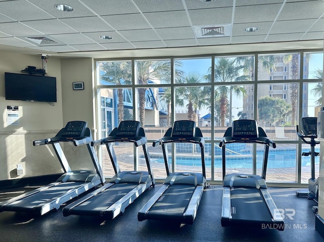 workout area featuring a drop ceiling and a healthy amount of sunlight