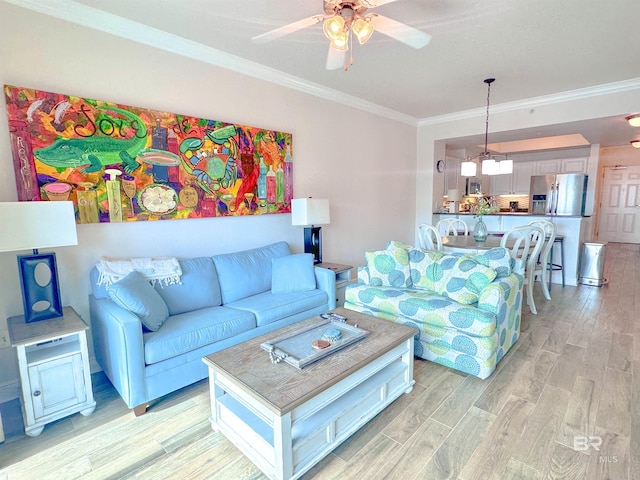 living room featuring light hardwood / wood-style floors, ceiling fan, and crown molding