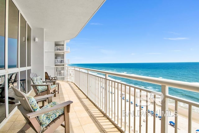 balcony featuring a beach view and a water view