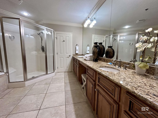 bathroom featuring vanity, tile patterned flooring, crown molding, and a shower with shower door