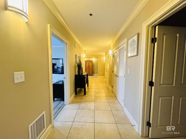 hall featuring light tile patterned flooring and crown molding