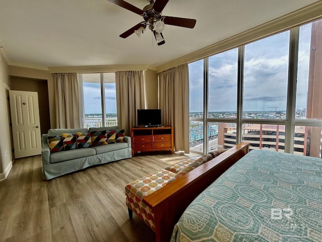 bedroom featuring ceiling fan, crown molding, and hardwood / wood-style flooring