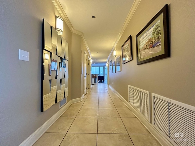 hall featuring light tile patterned floors and crown molding