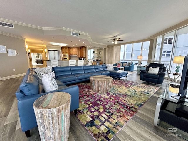 living room featuring ceiling fan, ornamental molding, and hardwood / wood-style floors