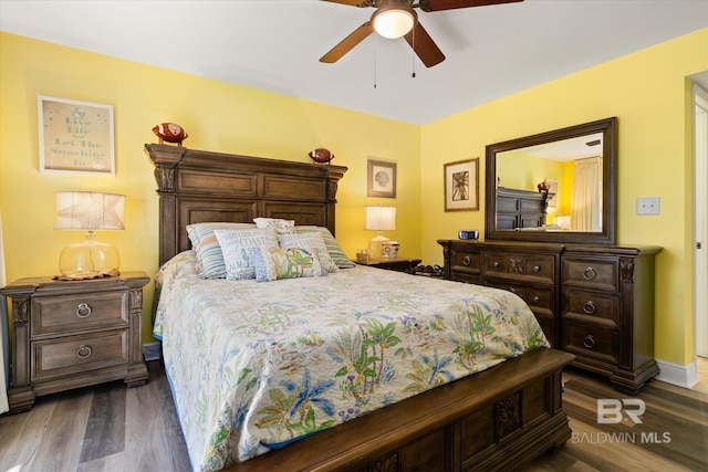 bedroom with dark wood-type flooring, ceiling fan, and baseboards