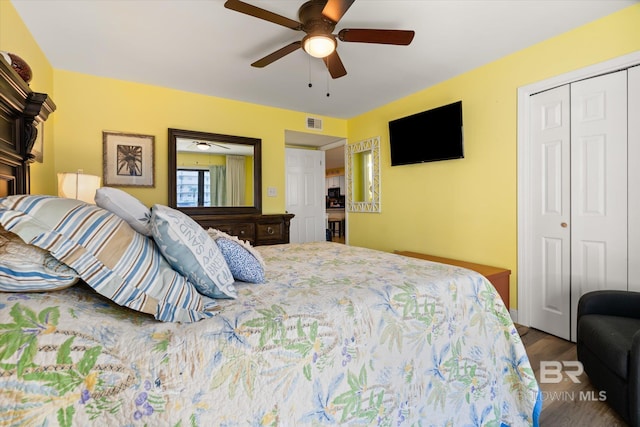 bedroom with a ceiling fan, visible vents, a closet, and wood finished floors