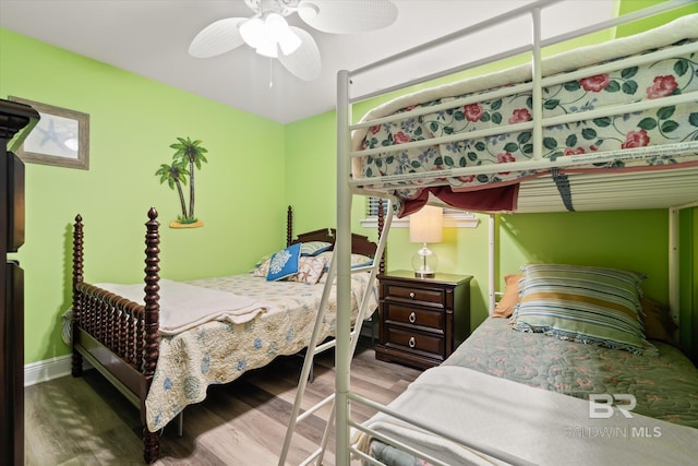 bedroom with ceiling fan, baseboards, and wood finished floors