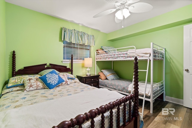 bedroom with dark wood-style floors, ceiling fan, and baseboards