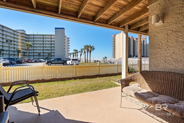 view of patio / terrace featuring a view of city and fence