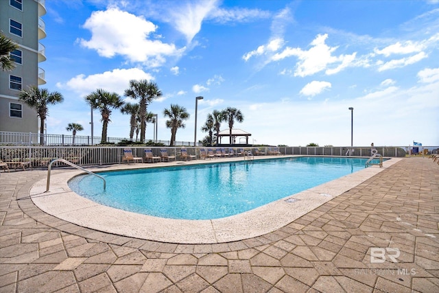 community pool with fence and a patio