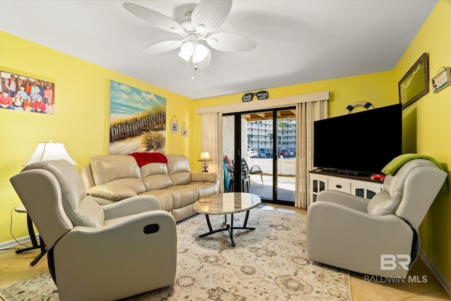 living area featuring a ceiling fan, light tile patterned flooring, and baseboards