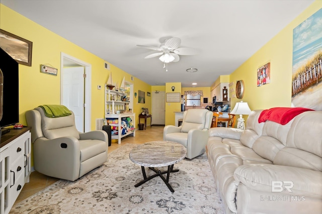 living area with light tile patterned floors, ceiling fan, and visible vents